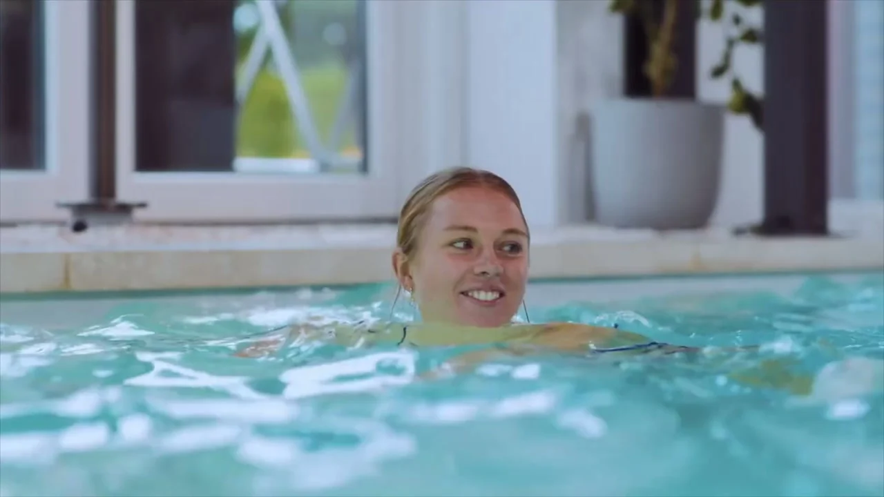 Standbild aus dem RivieraPool-Imagefilm — Schwimmen im beleuchteten Innenpool